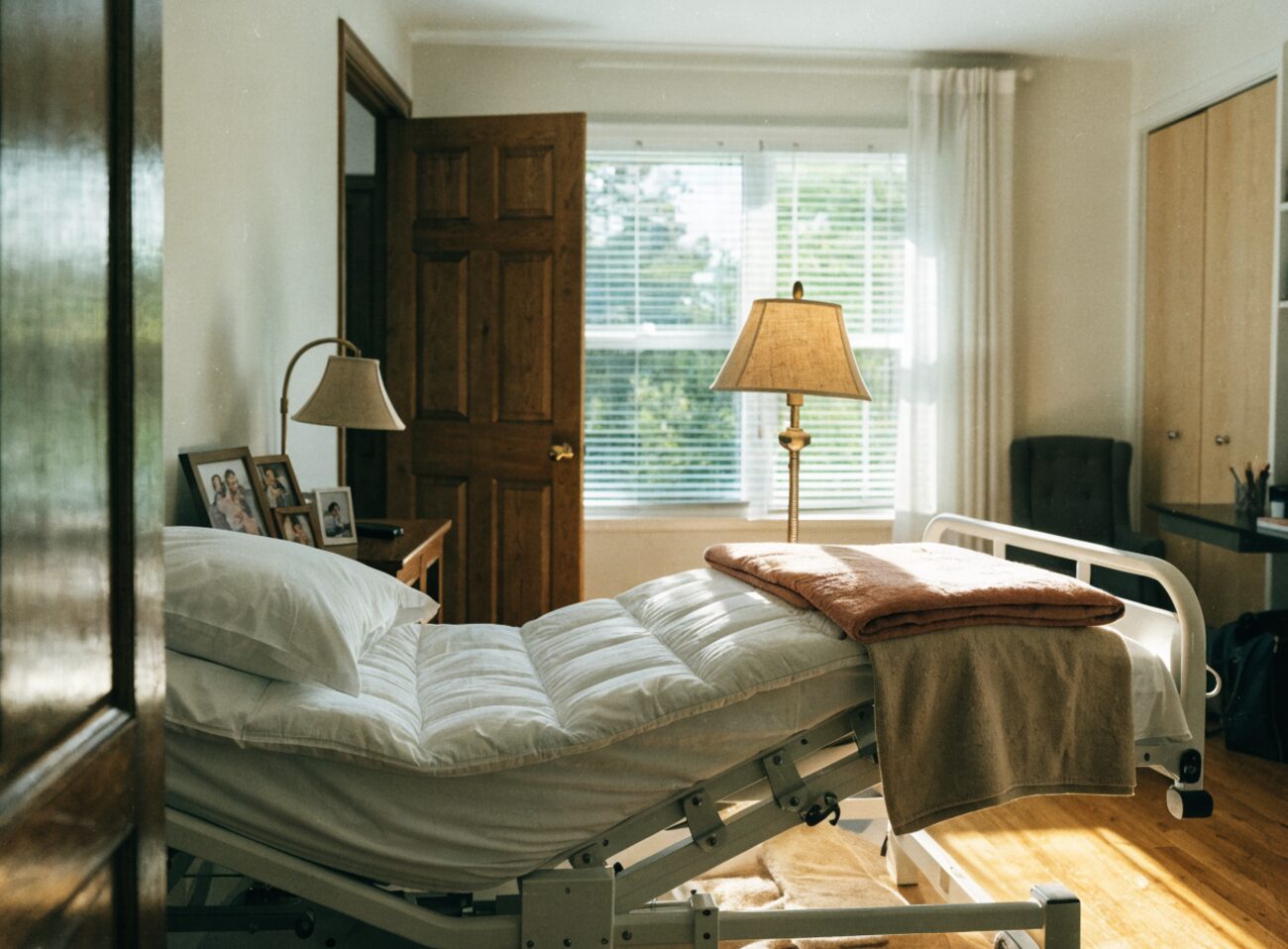 A hospital bed made up in a sunlit spare bedroom, ready for someone coming home